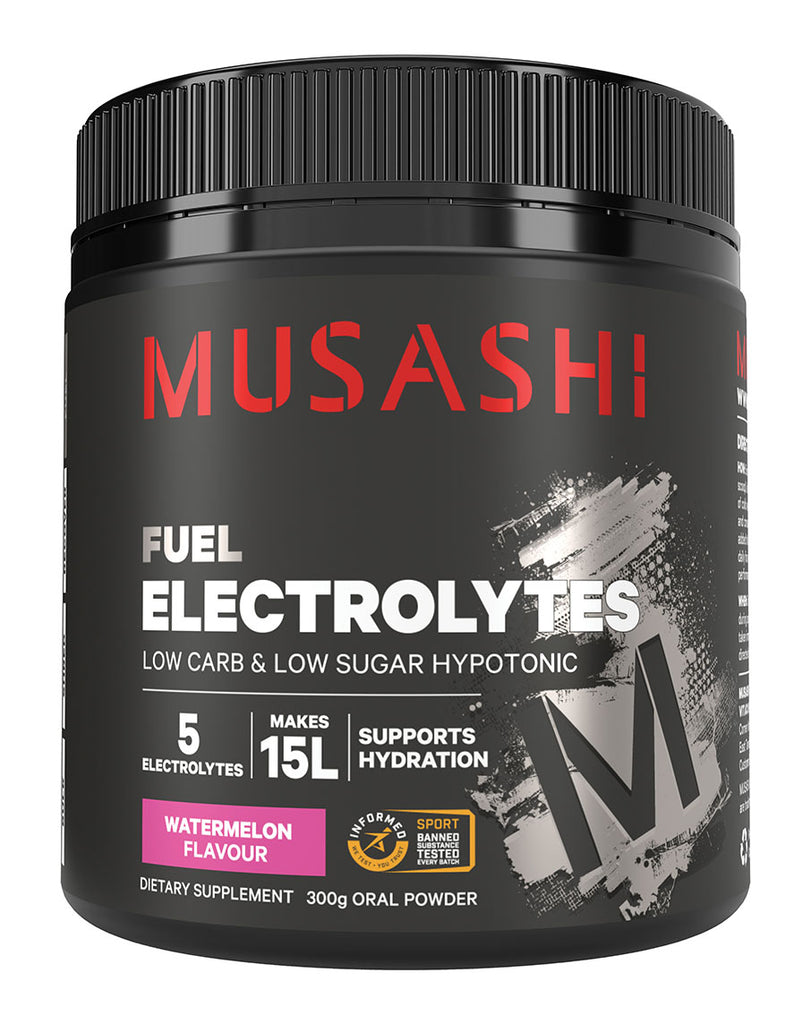 Front-facing Musashi Electrolytes 300g Watermelon – black matte tub with red branding, metallic “M” brushstroke design, and label showing 5 electrolytes and 15L hydration capacity.